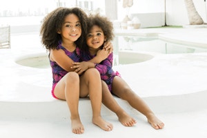 two little girls sitting by the pool